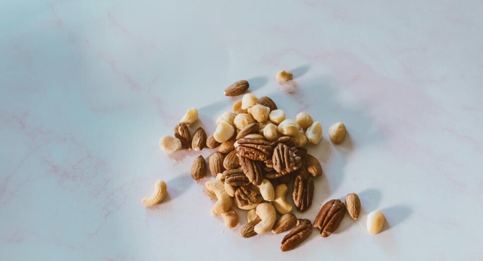 Close-up of assorted nuts on a marble surface, with natural lighting and texture.