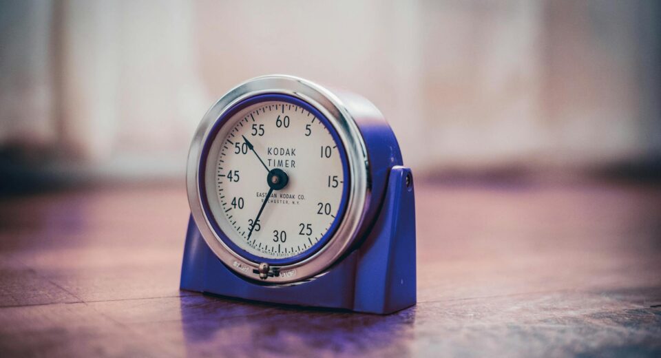 Close-up of a vintage Kodak timer on a wooden surface, highlighting retro design and time measurement.