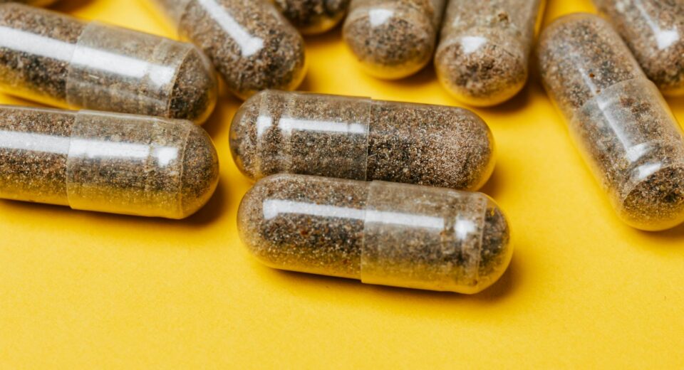 Close-up of clear capsules on a vibrant yellow surface, offering potential for health-related content