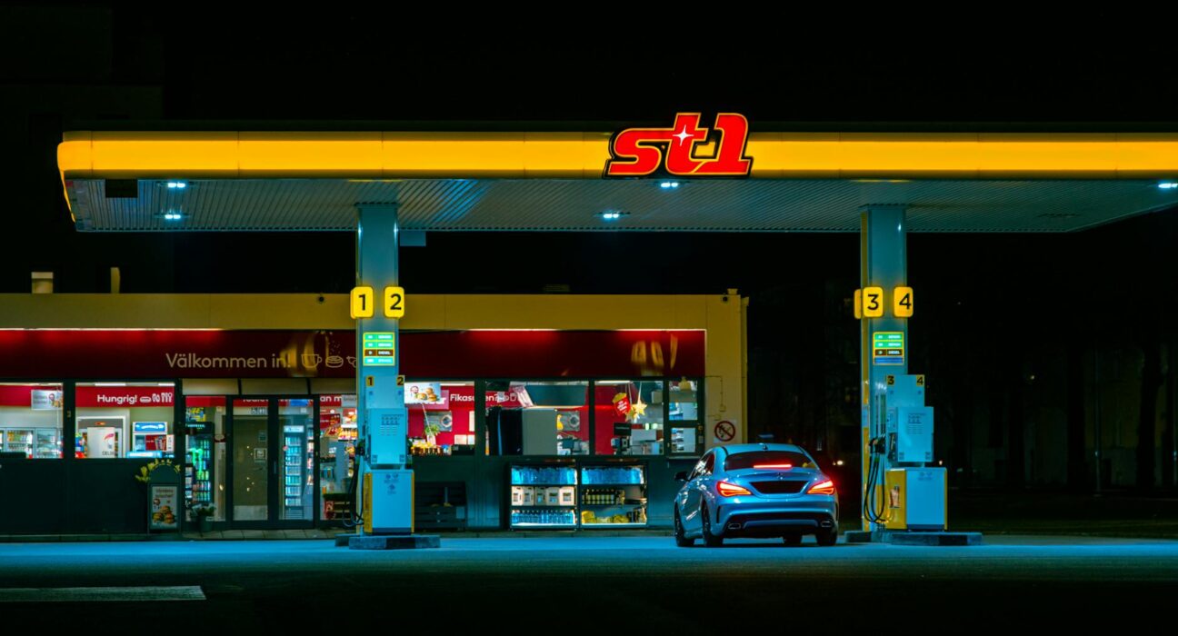 A car refuels at the illuminated St1 gas station in Jönköping, Sweden at night.