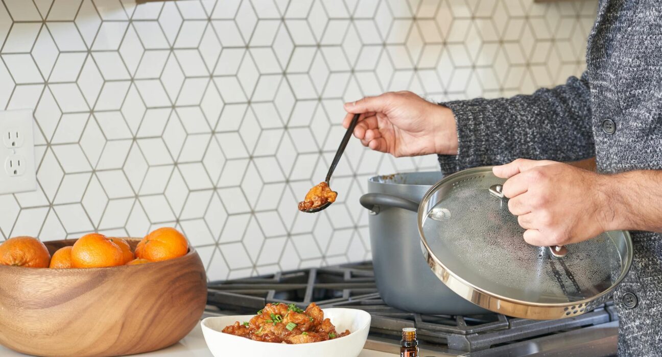 A person cooking a meal in a modern kitchen with fresh ingredients on display.