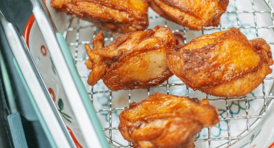 Golden brown fried chicken pieces cooling on a wire rack, perfect for a delicious meal.