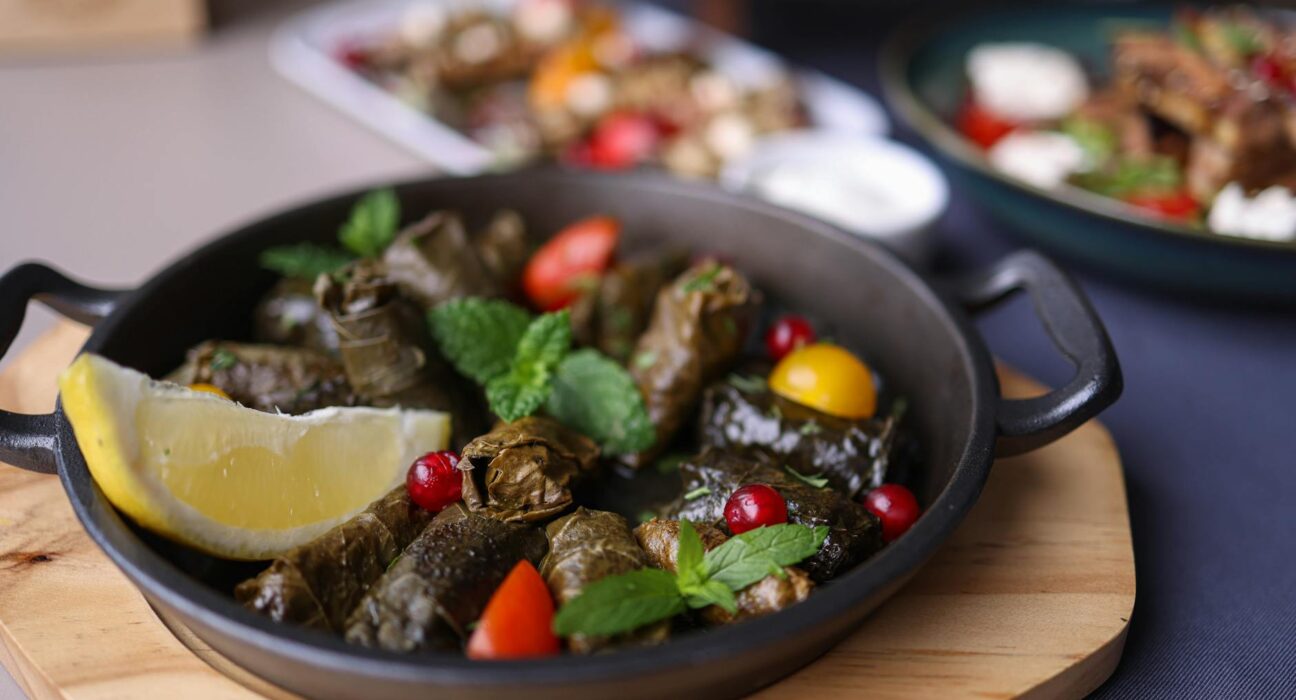 Delicious traditional dolma served with fresh garnish and lemon in a rustic setting.