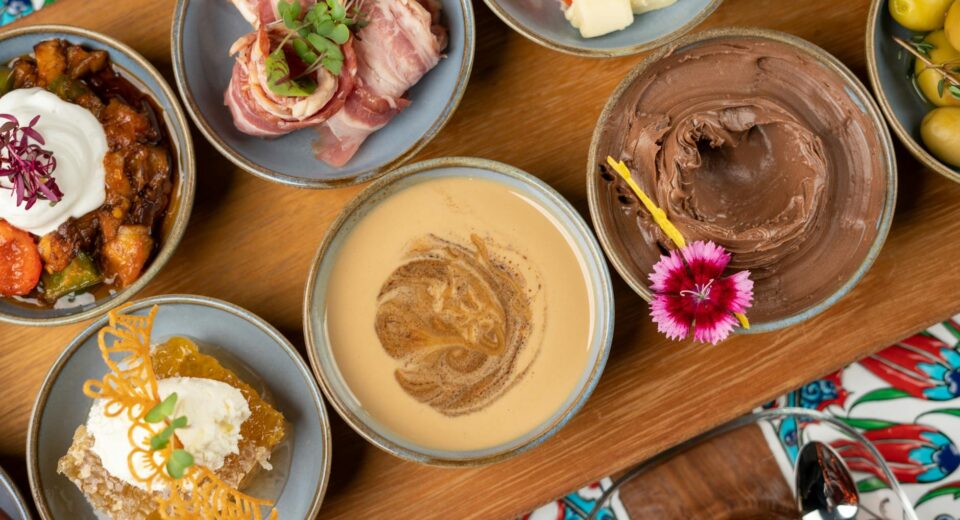 Top view of assorted Turkish meze dishes, showcasing vibrant colors and diverse flavors on a wooden platter.