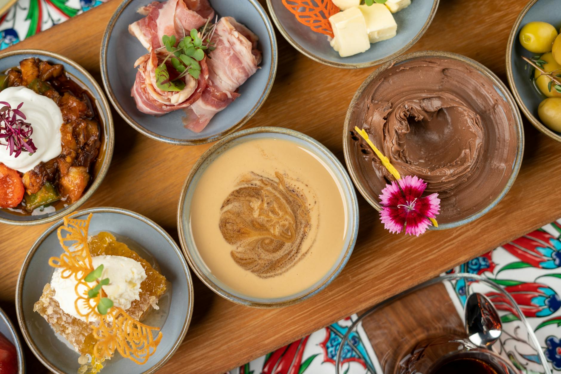 Top view of assorted Turkish meze dishes, showcasing vibrant colors and diverse flavors on a wooden platter.