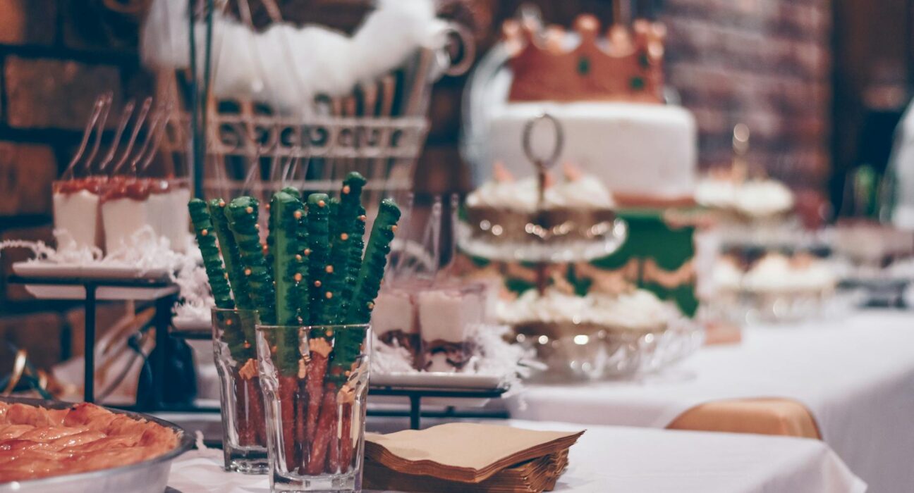 Close-up of a beautifully decorated dessert table at a festive event indoors.