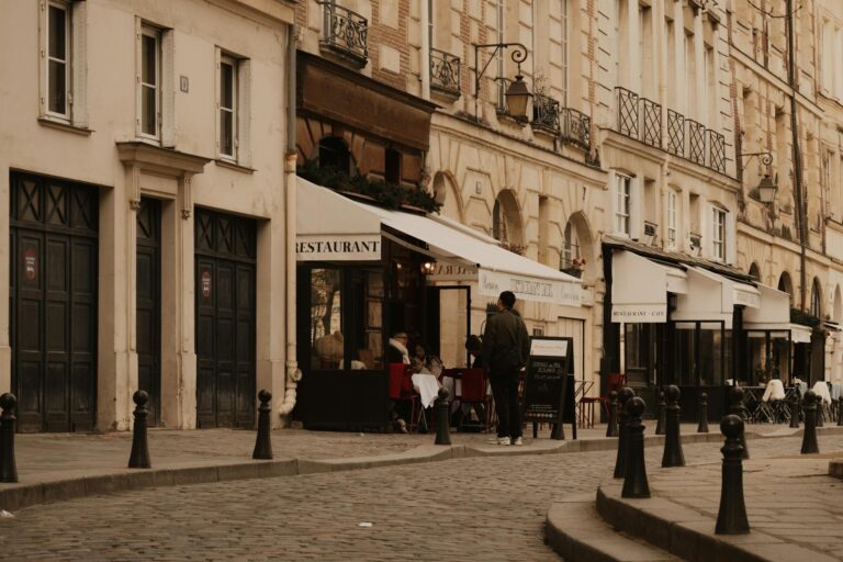 Cobblestone street in Paris with cafes and classic architecture, evoking a vintage urban mood.