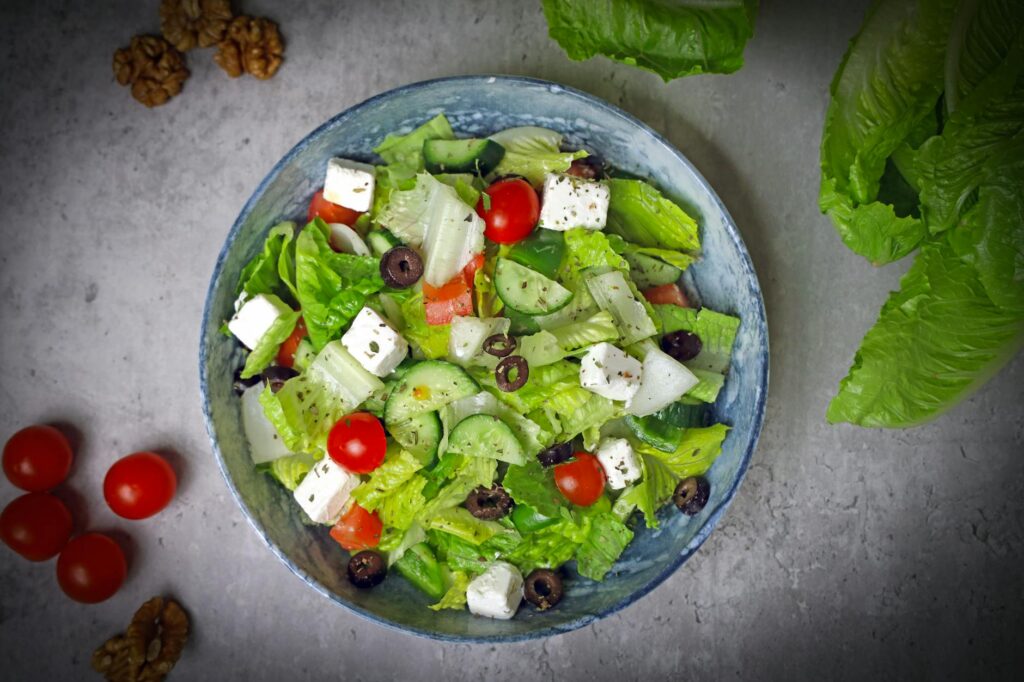 Top-down view of a vibrant Greek salad with fresh vegetables and feta cheese.