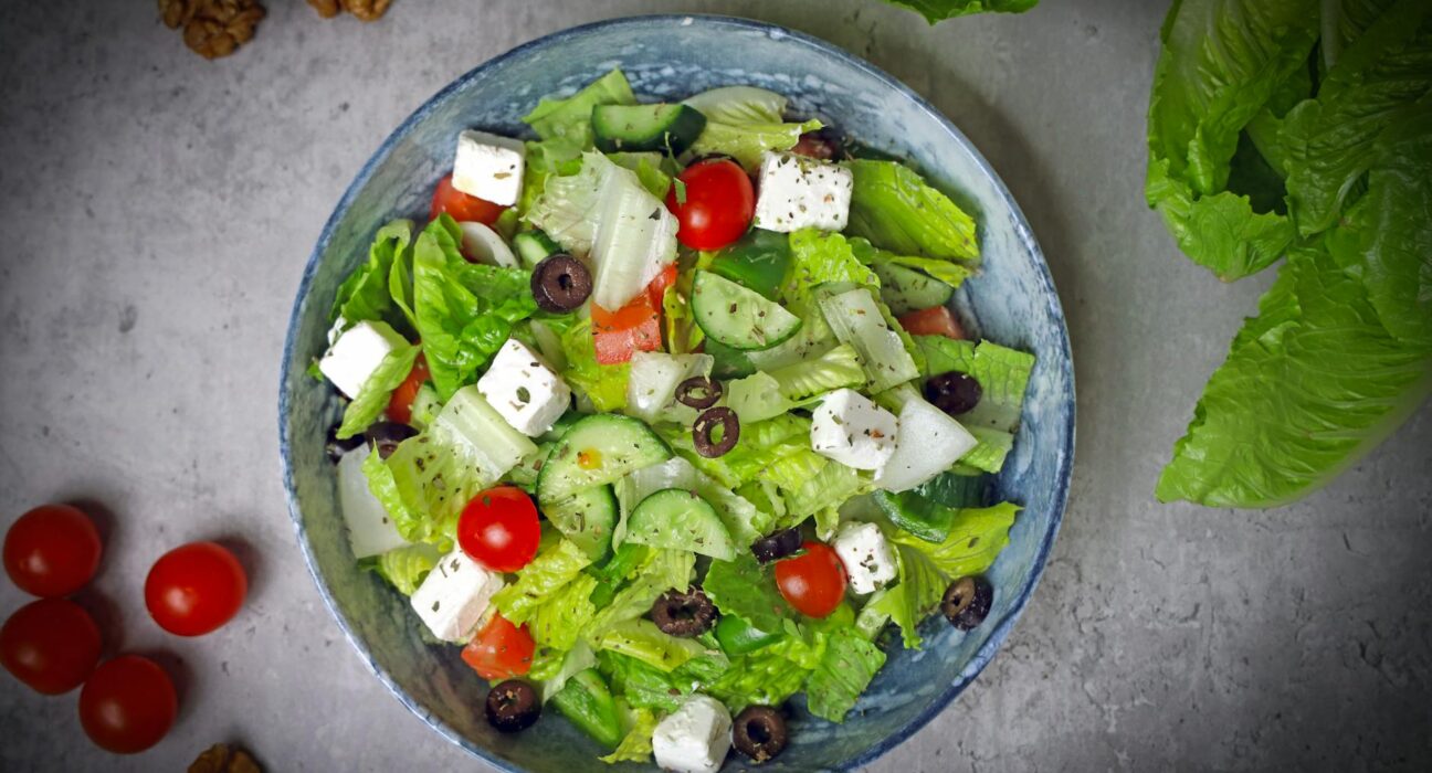 Top-down view of a vibrant Greek salad with fresh vegetables and feta cheese.