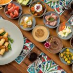 Colorful Turkish meze platter with diverse dishes on a wooden table, offering a rich culinary experience.