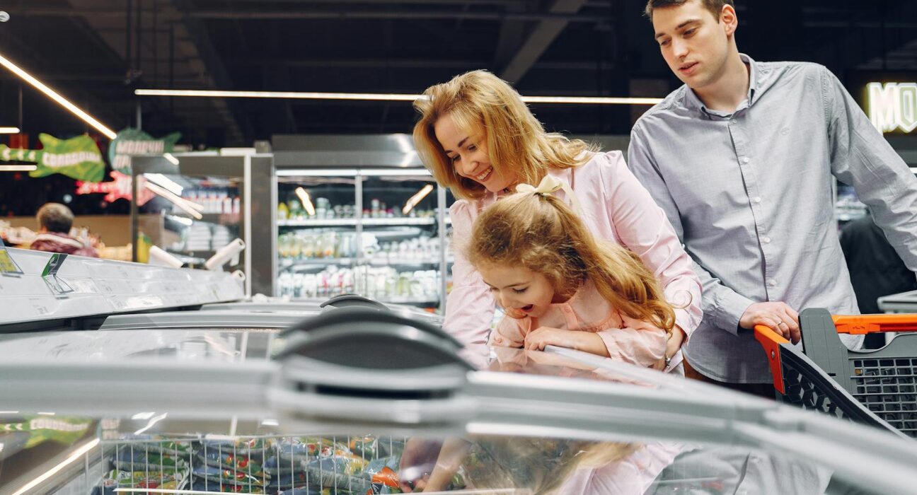 A family enjoying time together while shopping in a supermarket aisle.