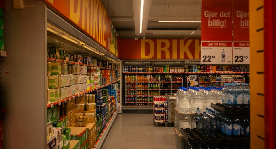 Colorful drink aisle in a supermarket with signage promoting deals.