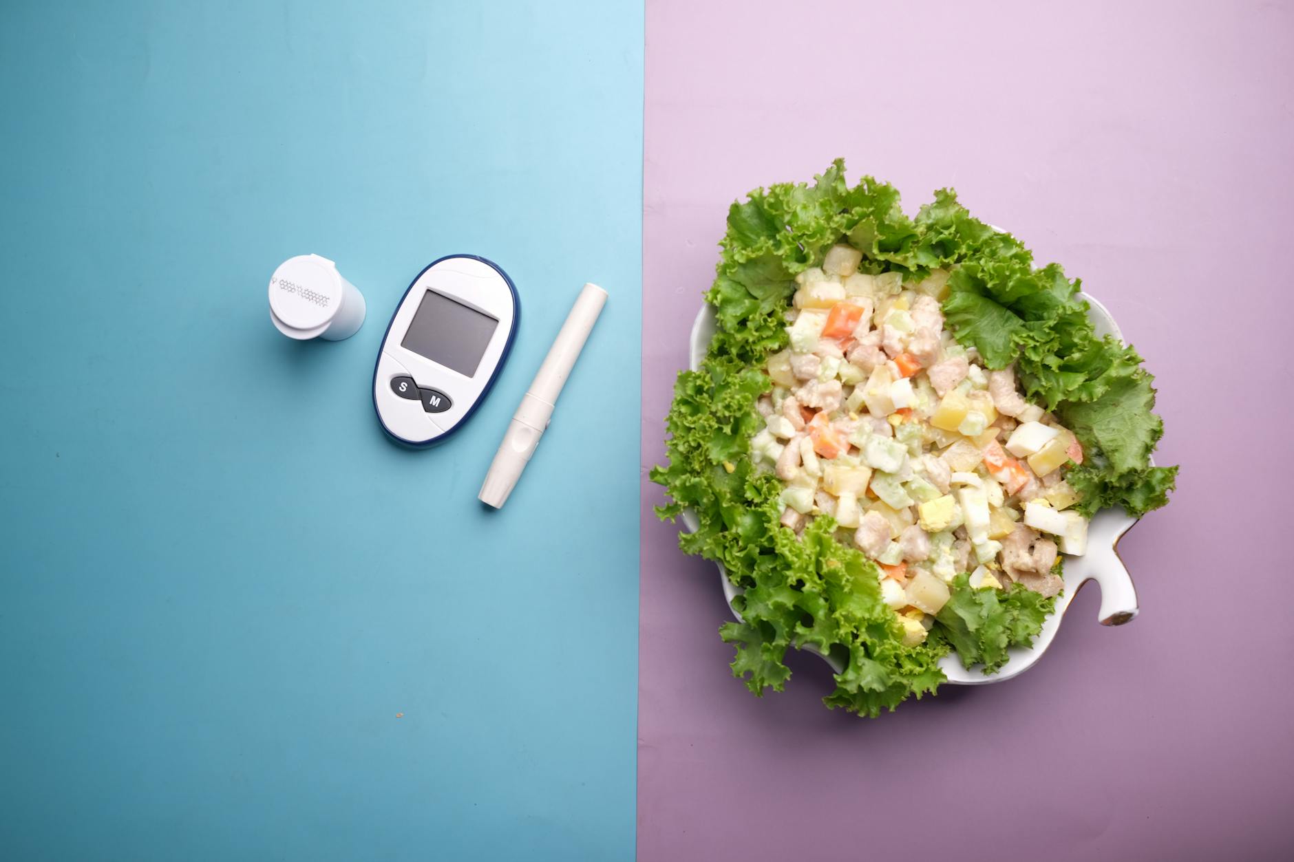 Top view of diabetes equipment and fresh salad representing healthy living.