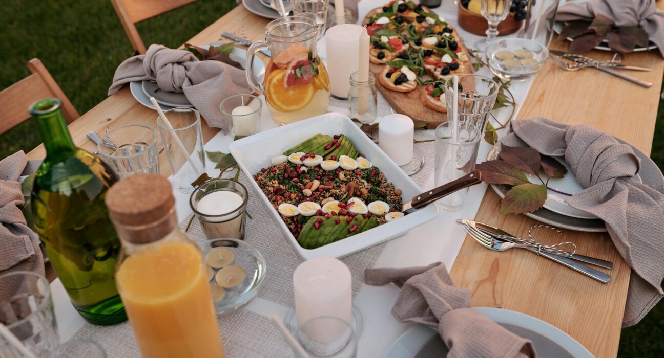 Beautiful outdoor dinner table with delicious food and elegant setting for a summer evening gathering.