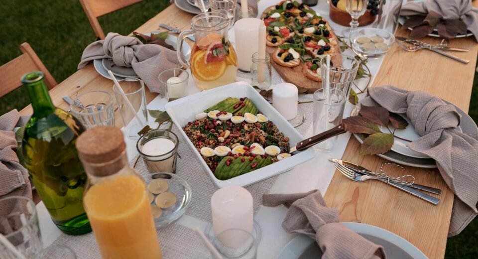Beautiful outdoor dinner table with delicious food and elegant setting for a summer evening gathering.