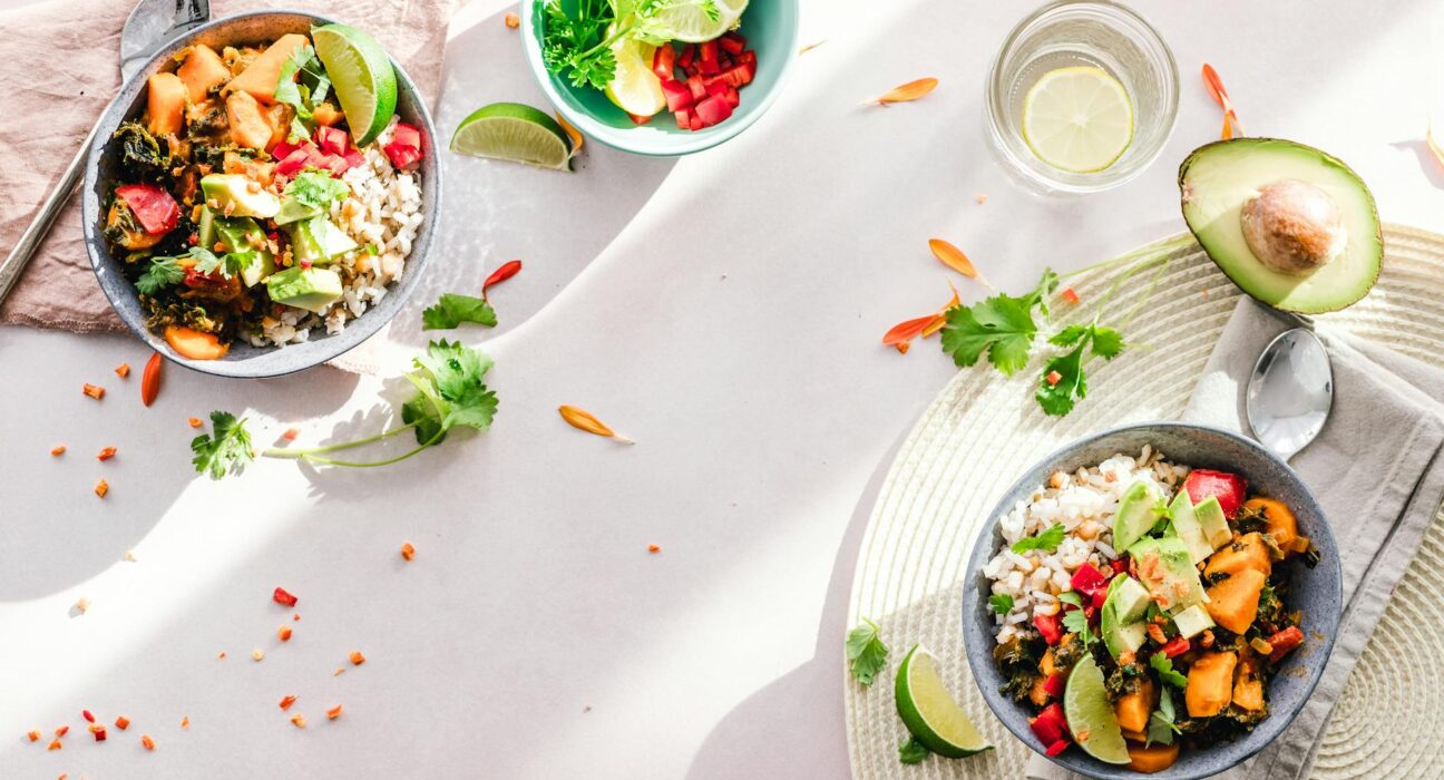 Top-down view of vibrant vegan bowls filled with fresh vegetables, perfect for a healthy meal.