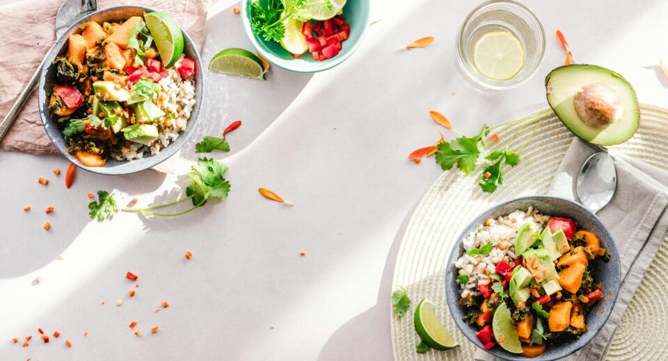 Top-down view of vibrant vegan bowls filled with fresh vegetables, perfect for a healthy meal.