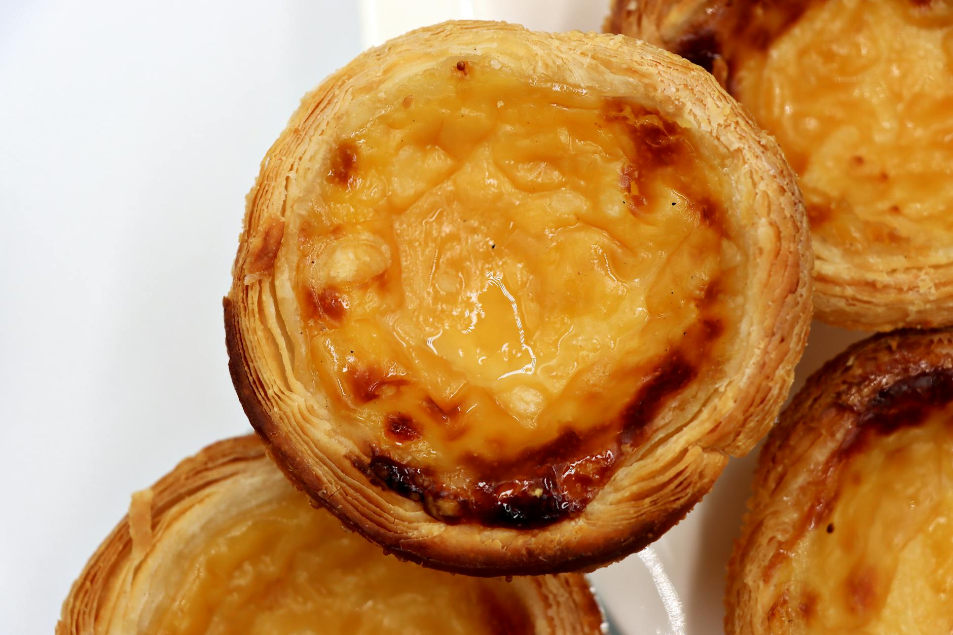 Delicious close-up of traditional Portuguese custard tarts showcasing creamy custard and flaky pastry.