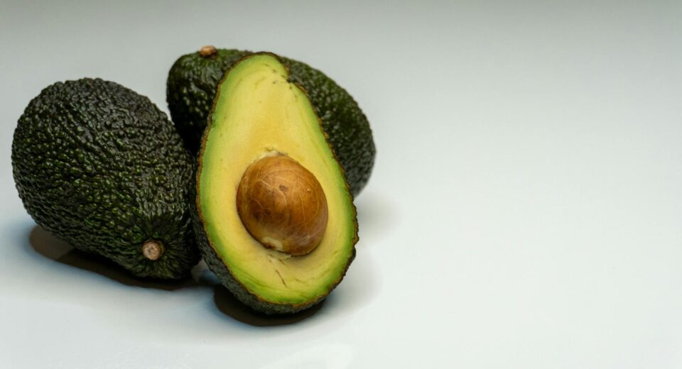 Close-up of fresh avocados on a white surface highlighting healthy eating.