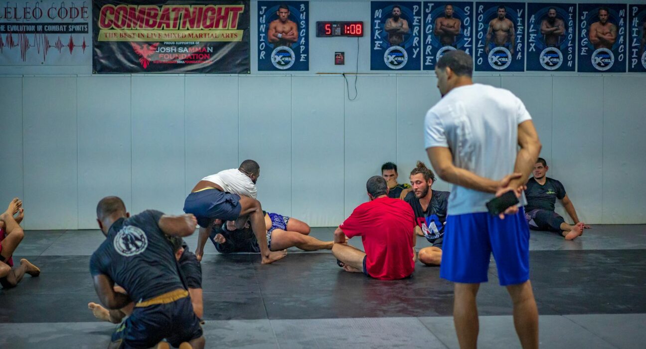 Mixed martial arts fighters practicing techniques during a gym session.