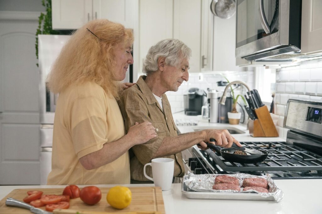 Senior couple enjoying quality time cooking together in a modern kitchen setting.