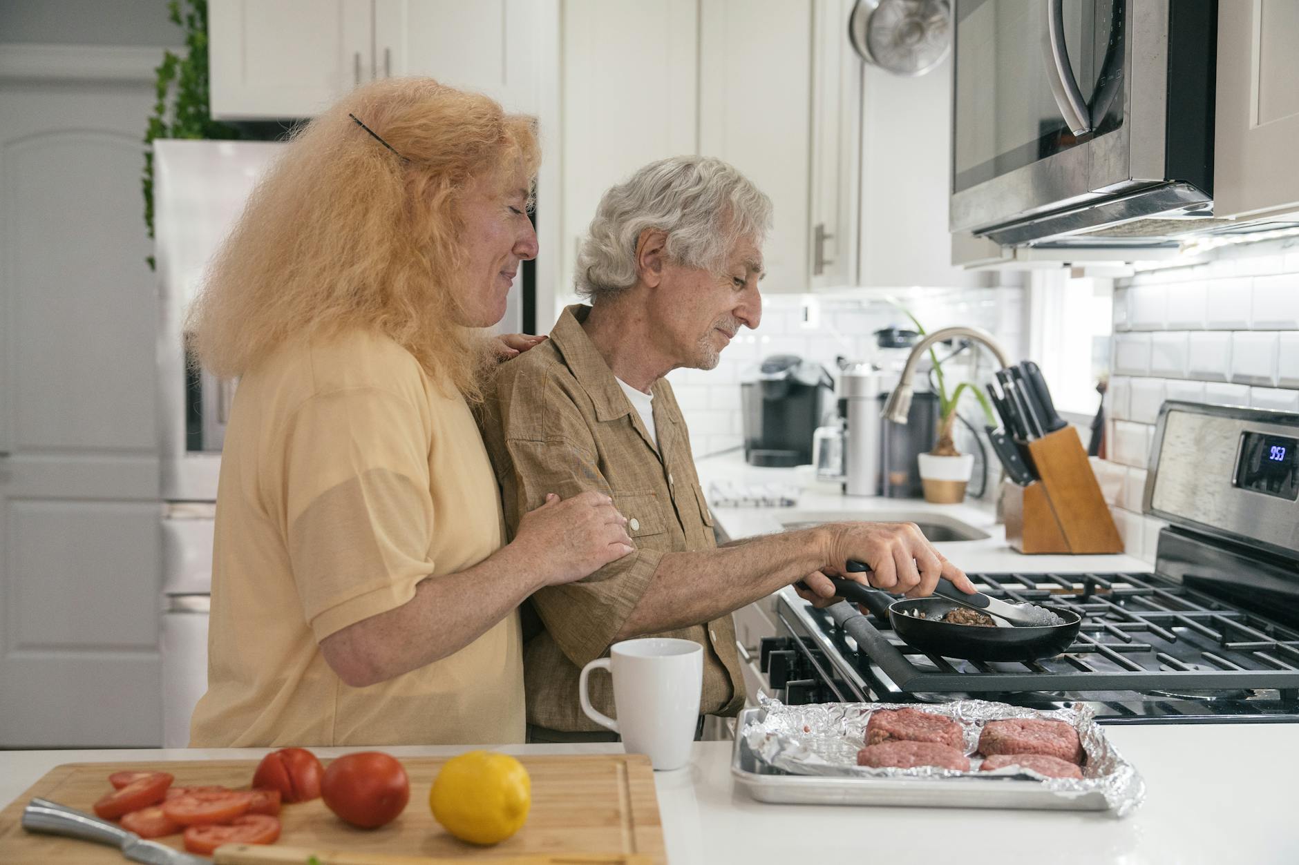 Senior couple enjoying quality time cooking together in a modern kitchen setting.