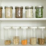 Neatly arranged pantry showcasing grains in glass jars and dry goods in plastic containers.