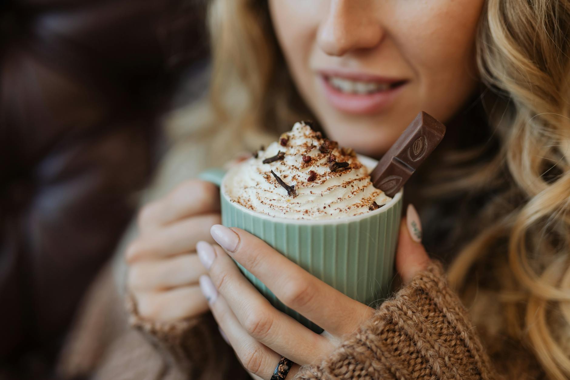 Warm up with a delicious hot chocolate topped with whipped cream and chocolate shavings in a cozy setting.