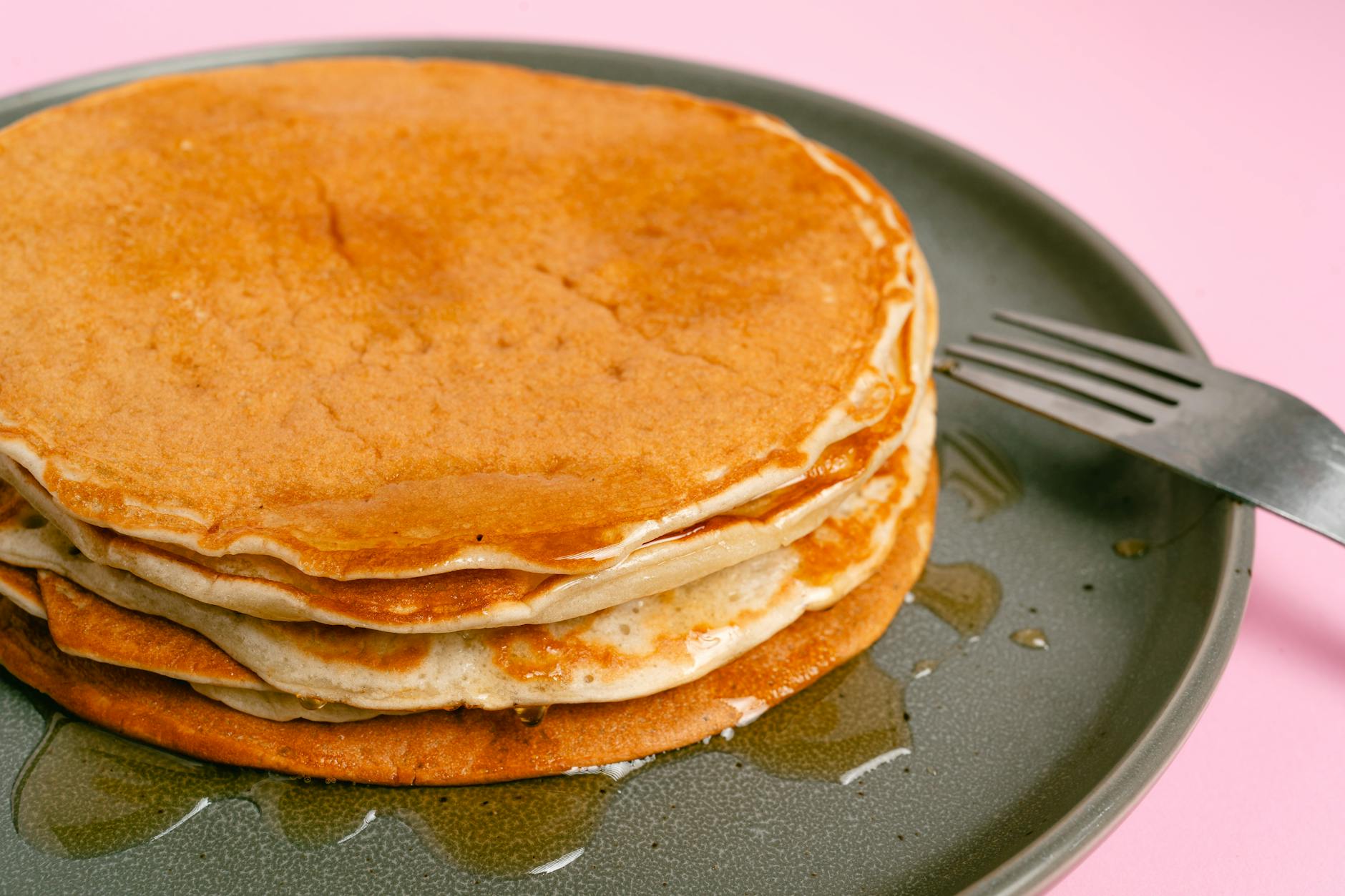 Stack of pancakes drizzled with maple syrup, perfect breakfast delight.