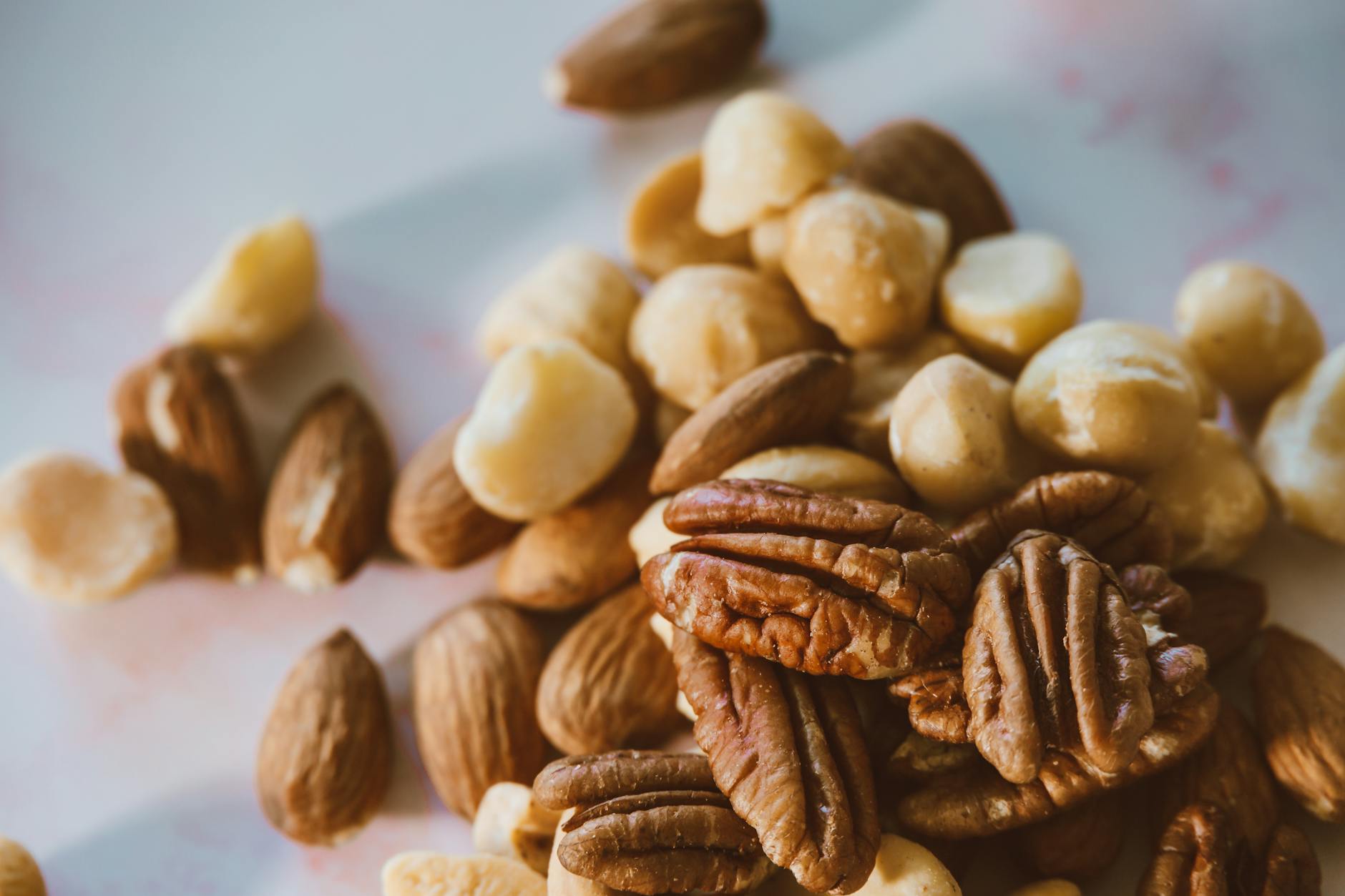 A close-up image showcasing a variety of mixed nuts including almonds, pecans, and macadamias.