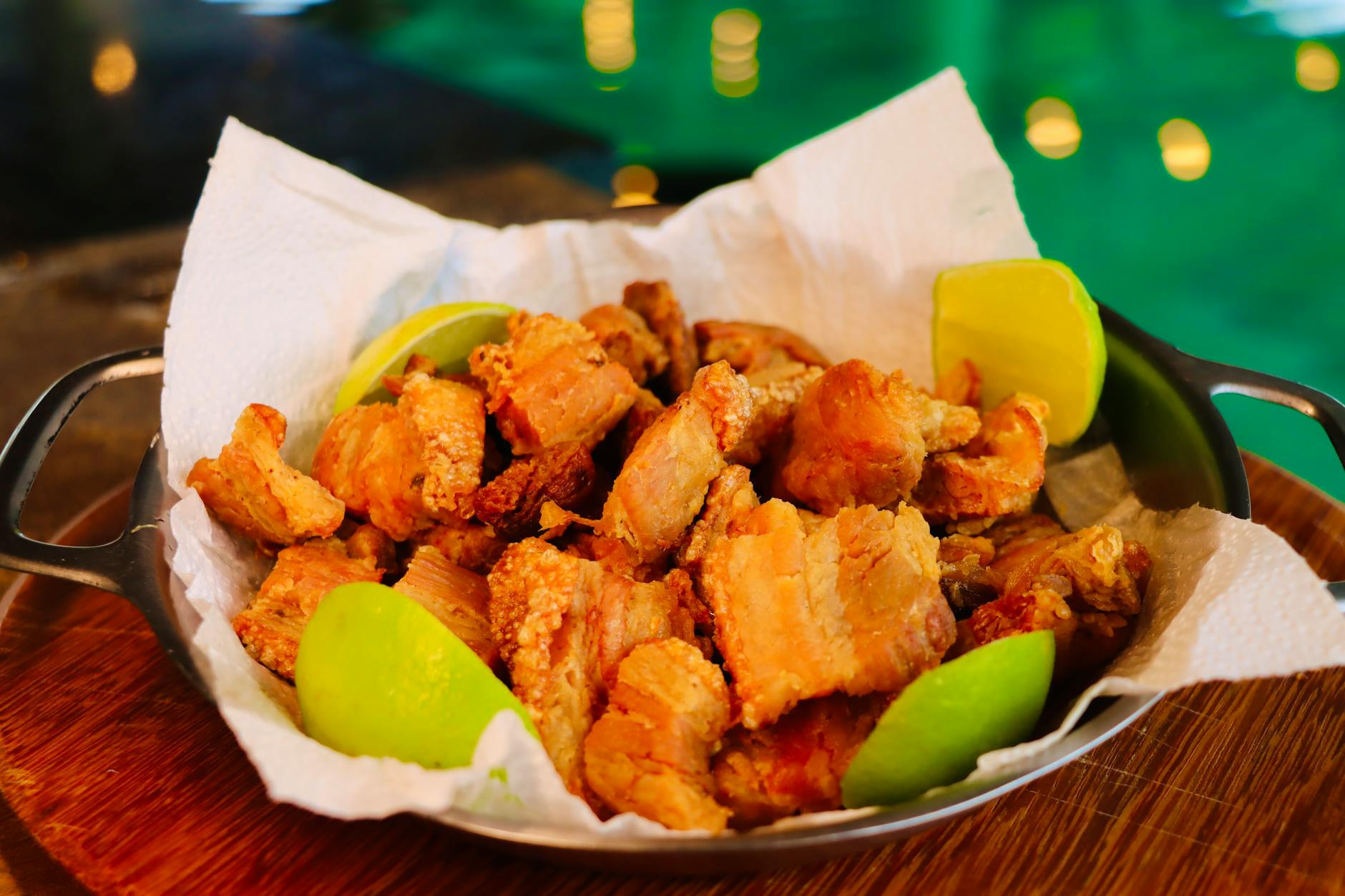 Delicious crispy pork belly served with fresh lime wedges, perfect for a savory treat.