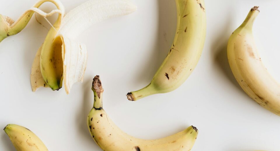 A flat lay photo of ripe bananas on a white background, showcasing healthy eating and minimalism.