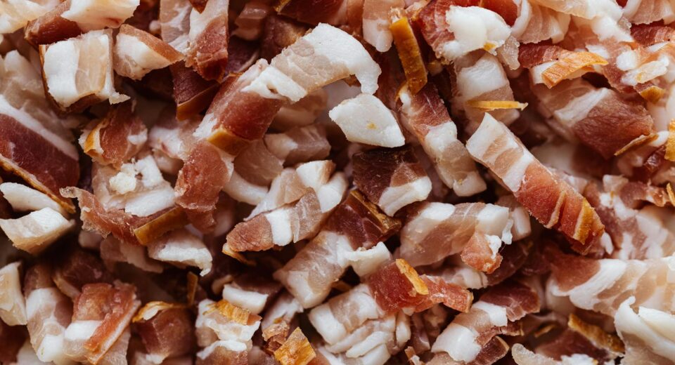 Closeup top view heap of delicious scrumptious pork bellies bacon cut into small slices before cooking process