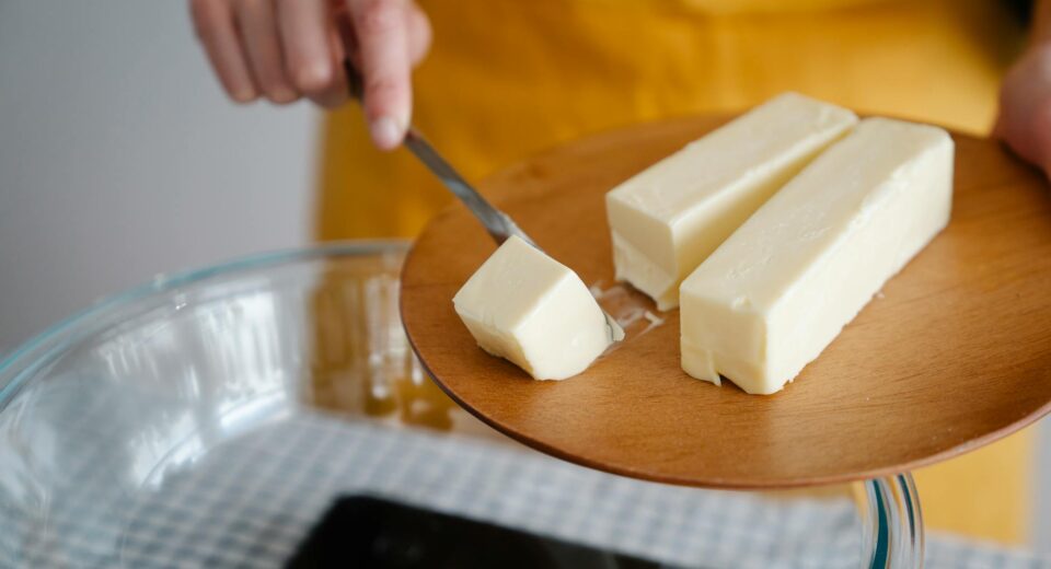 Focused shot of cutting butter for meal preparation, essential cooking ingredient.