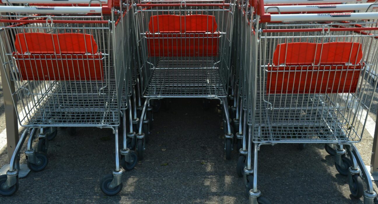 Neatly arranged shopping carts lined up in an outdoor parking lot.